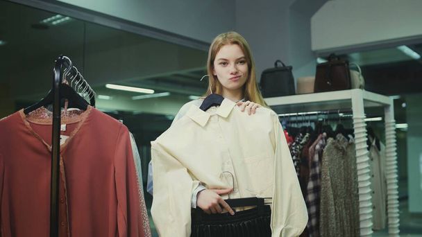 Mujer de compras ver más vestidos en perchas en la tienda boutique de ropa de moda
 - Foto, Imagen