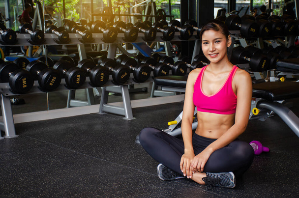 Fit adult woman resting in gym after a hard workout, Beautiful woman sitting at the gym smiling, Fitness concept. - Photo, Image