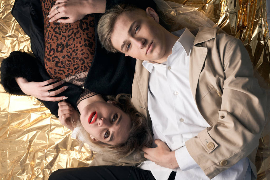 Couple élégant posant sur un fond doré à partir d'une feuille couchée. - Photo, image