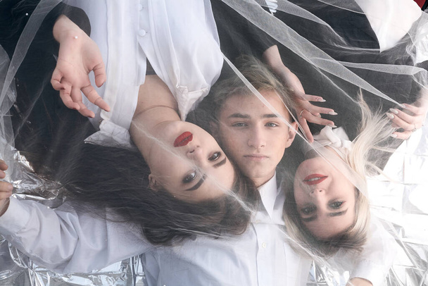 Retrato de tres jóvenes hermosos bajo un tejido de tul
. - Foto, imagen