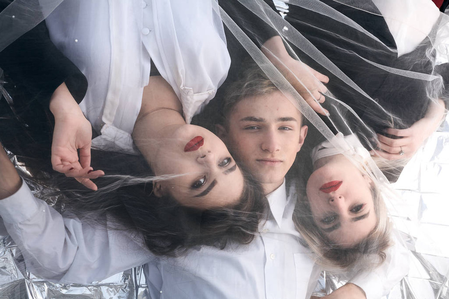Portrait of three beautiful young people under a tulle fabric. - Photo, Image