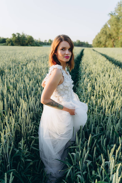 attractive woman in long white dress standing  in the summer meadow, portrait  - Fotografie, Obrázek