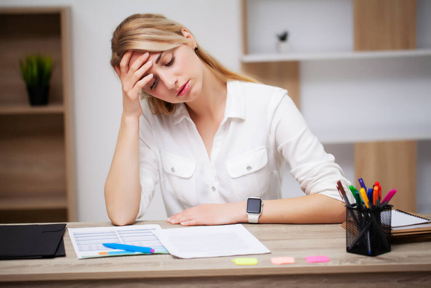 Mujer de negocios cansada trabajando con documentos en la oficina en el escritorio - Foto, imagen