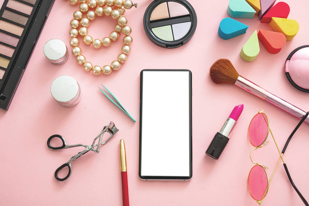 Accesorios para mujer y smartphone con pantalla blanca en blanco sobre fondo de color rosa, plano, vista superior. Espacio de trabajo del blogger de moda, espacio de copia
 - Foto, Imagen