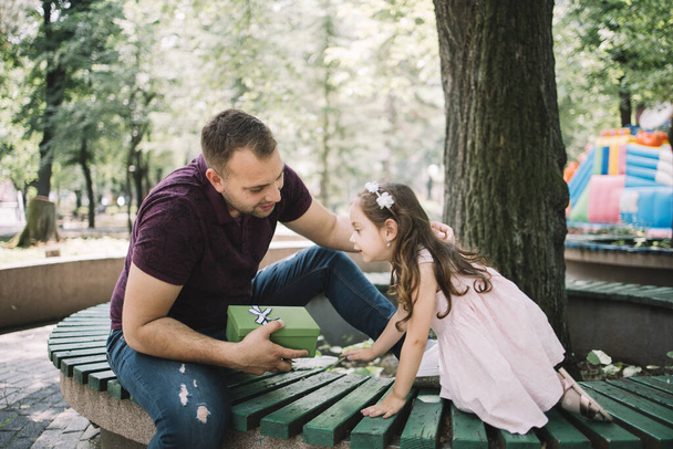 Little girl giving present to her father outdoor - Photo, image