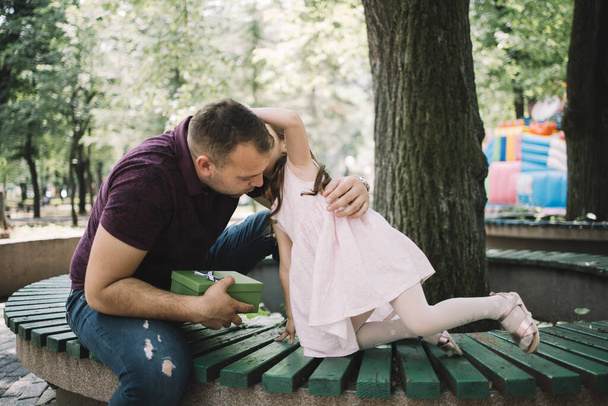 Daughter whispering to her daddy who is holding gift - Fotografie, Obrázek