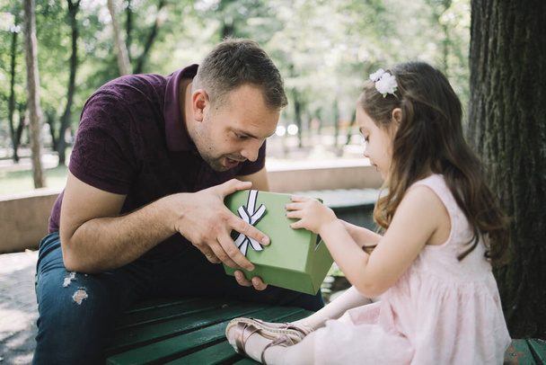 Surprised dad and daughter looking in opened gift box - Photo, image