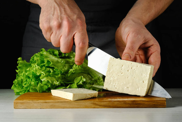Šéf krájí tofu sýr na dřevěné desce - Fotografie, Obrázek