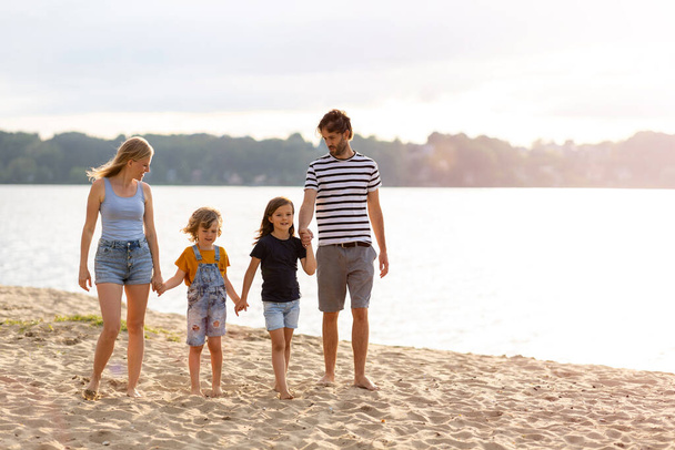 ビーチで一日を過ごす4人の家族のショット - 写真・画像