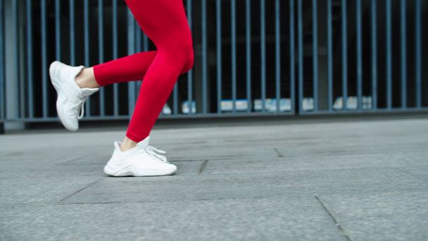 Close up female legs running outdoor in slow motion. Fitness woman training run - 写真・画像