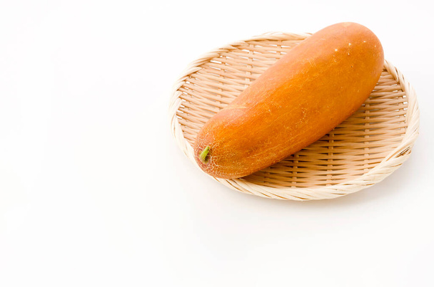 Moui, Okinawan yellow cucumber in bamboo colander on white background - Photo, Image