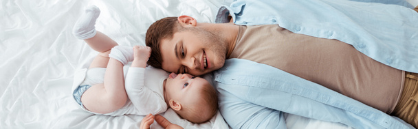 top view of happy father lying face to face with cute baby boy, horizontal image - Φωτογραφία, εικόνα