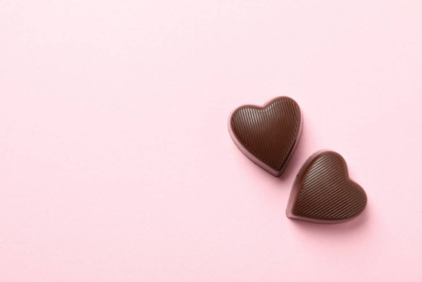 Doces de chocolate na forma de coração em fundo rosa
 - Foto, Imagem