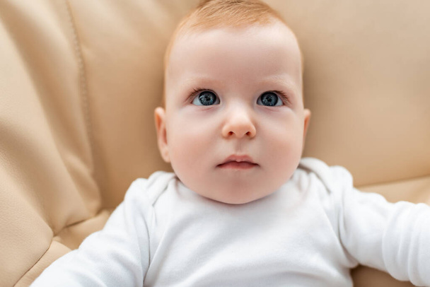 top view of adorable infant boy lying and looking away - Photo, Image