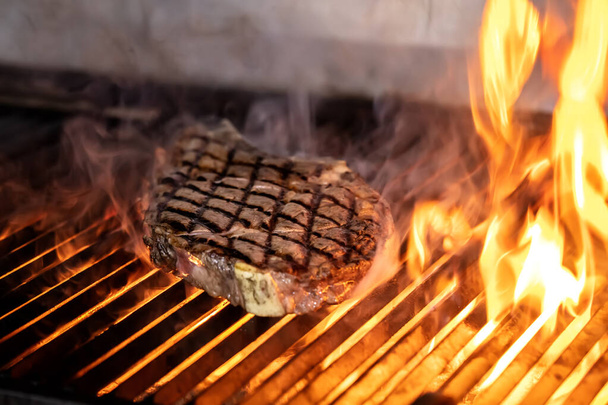 Hovězí steaky na grilu s plamenama. Grilování steaků na hořícím grilu a výstřel se selektivním zaměřením. - Fotografie, Obrázek