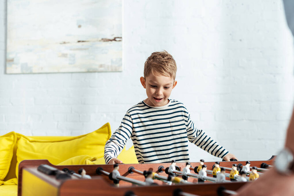 cropped view of man playing table soccer with excited son - Fotoğraf, Görsel