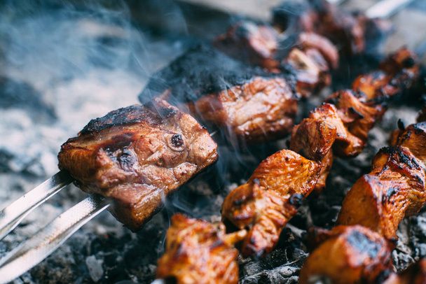 Skewers of pork ribs and chicken on skewers. Grilled meat. Cooking outdoors. - Photo, Image