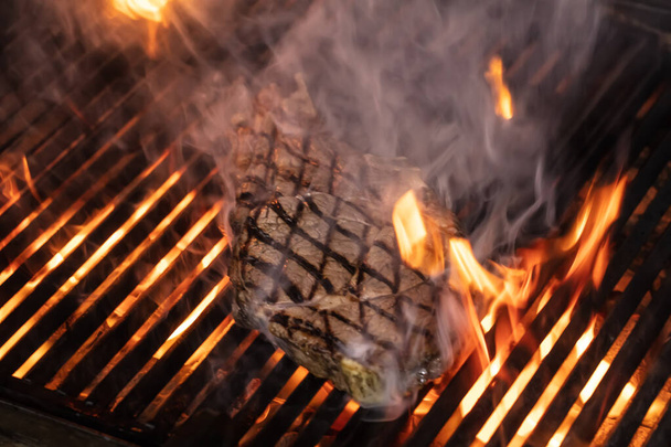 Carne de res en la parrilla con llamas. Carne de vacuno T-bone steaks (dallas steaks) en la parrilla con llamas
. - Foto, imagen
