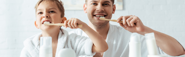 selective focus of happy father and son brushing teeth together, panoramic shot - Photo, Image