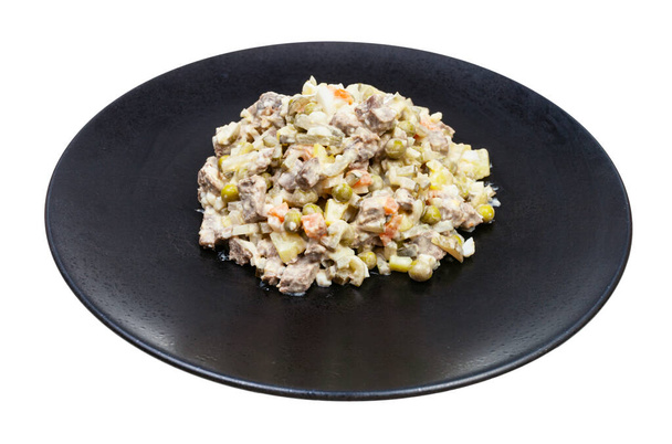 portion of russian Olivier salad on black plate isolated on white background - Photo, Image