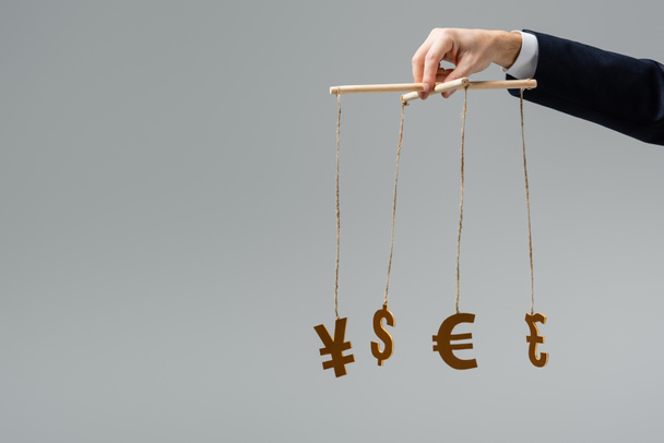 обрезанный взгляд бизнесмена с валютными знаками на струнах, изолированных на сером
 - Фото, изображение