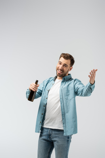 smiling young man with bottle of beer isolated on grey - Foto, Imagem