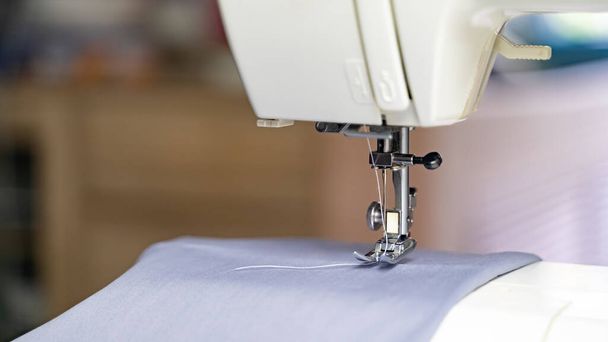 Máquina de coser eléctrica con tela e hilo
 - Foto, imagen