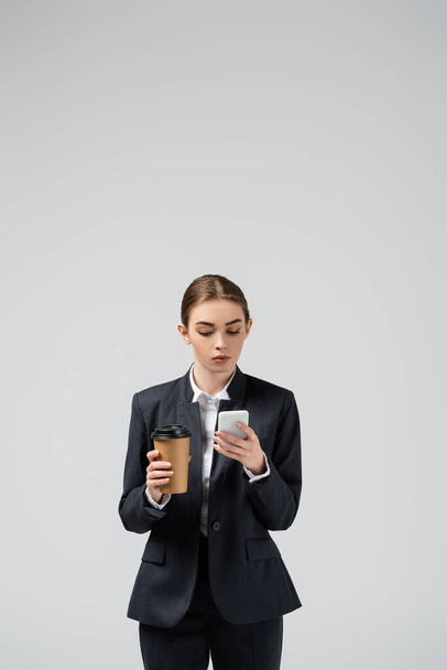 joven empresaria con café para ir aislado en gris
 - Foto, imagen