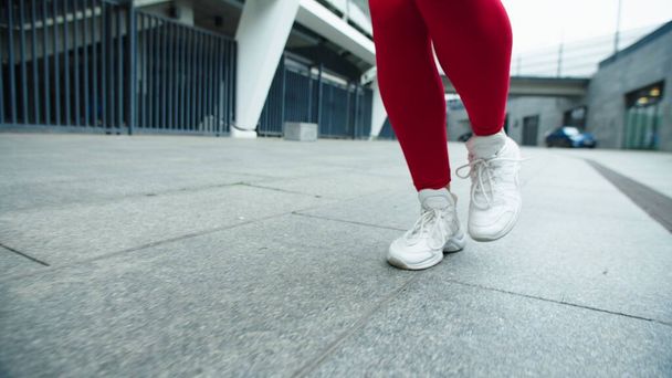 Close up female legs running on urban street. Woman legs jogging outdoor. - Photo, Image
