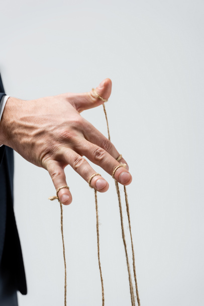 partial view of puppeteer with strings on fingers isolated on grey - Photo, Image