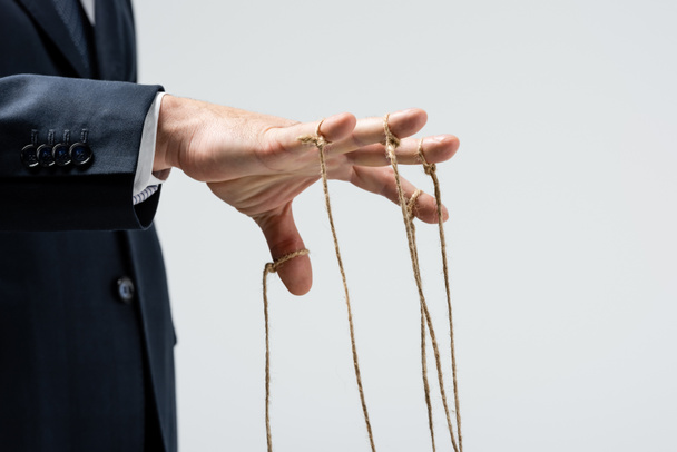 vista cortada de marionetista com cordas em dedos isolados em cinza
 - Foto, Imagem