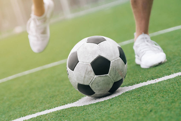 Las piernas del fútbol se cierran al lado del fútbol. concepto marca un gol para pasar a otro jugador durante el juego
 - Foto, Imagen