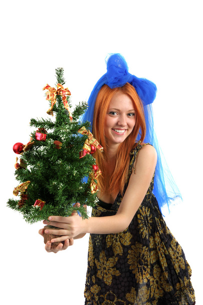 The young beautiful girl in a dress holds a Christmas tree on is - Fotoğraf, Görsel