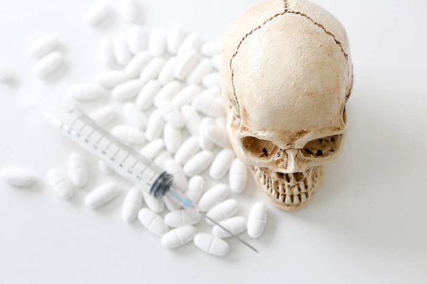 Skull and syringe. medical vials, skull and blurry syringe. Medical risk of virus abuse and death. - Photo, Image