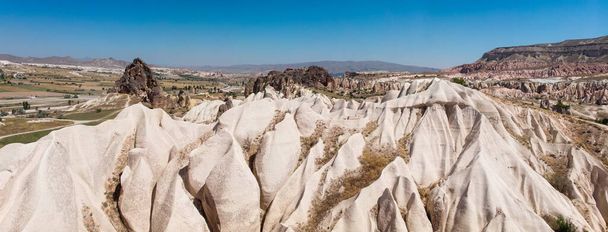 Вид с воздуха на Национальный парк Гореме, Тарихи Милли Парки, Турция. Типичные скальные образования Каппадокии со сказочными трубами и пустынным ландшафтом. Туристические направления, отдых и приключения
 - Фото, изображение