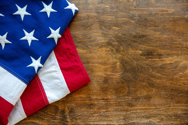 USA-Flagge gefaltet auf Holztischhintergrund. Ansicht der amerikanischen Flagge von oben, Kopierraum. Gedenktag und 4. Juli, Unabhängigkeitstag Attrappe, Vorlage,  - Foto, Bild