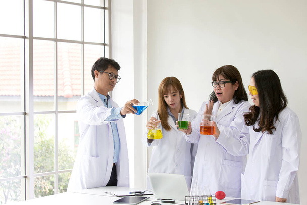 Tudományos teszt. Vegyész tudományos vizsgálati minőség. A csoport tudósa a laborban dolgozik. Egy férfi és három nő a kémia laborban. Ázsiai emberek. A laboratóriumban kutató élettudós. - Fotó, kép
