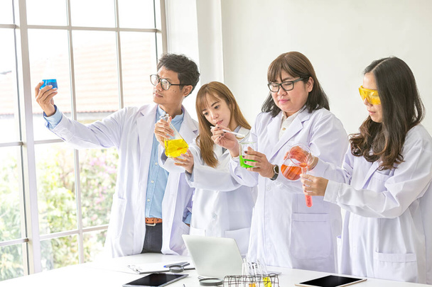 Science concept. Chemist scientific testing quality. Team Scientist working at laboratory. One Male and Three Female at chemistry lab. Life scientist researching in laboratory. Asian people. - Photo, Image