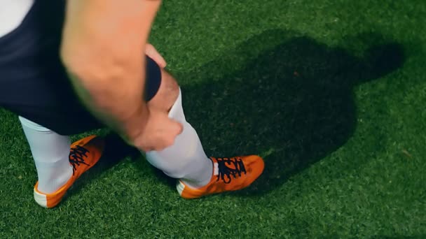 Professional soccer player adjusts his socks before the beginning of the match, 4k slow motion - Materiał filmowy, wideo