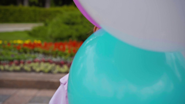 roztomilý a emocionální dítě vyčnívající jazyk v blízkosti balónky  - Záběry, video