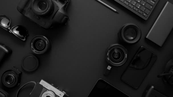 写真家のワークスペースのコンセプト。黒の背景に配置された様々なデジタルおよびアナログガジェット - 映像、動画