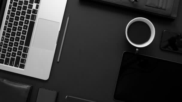 ビジネスデスクトップの概念。黒のテーブルの背景にオフィス用品やガジェットのミックス - 映像、動画