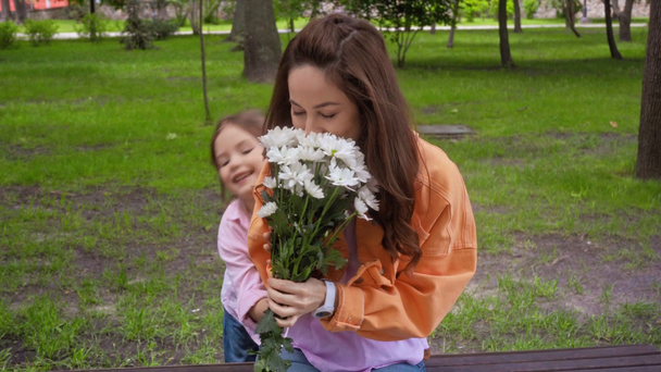 Mutlu çocuk parkta sürpriz annesine bir buket çiçek veriyor. - Video, Çekim