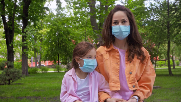 matka i córka w maskach medycznych w parku  - Materiał filmowy, wideo