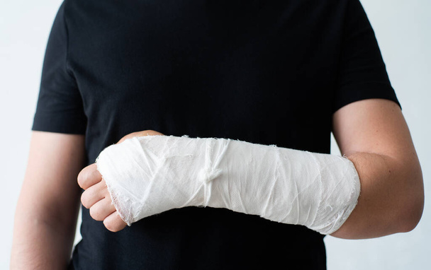 A broken hand in a gypsum bandage. Painful heavy movements of broken finger hands close-up - Fotografie, Obrázek