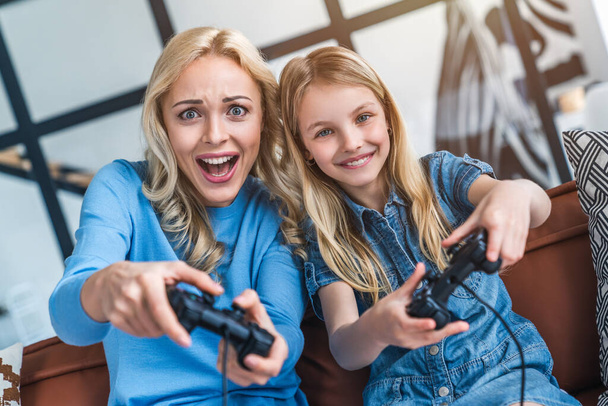 Mother and daughter in living room playing video game - Zdjęcie, obraz