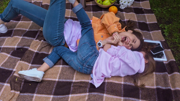άποψη υψηλής γωνίας της μητέρας και του παιδιού δείχνοντας με τα δάχτυλα και ξαπλωμένος σε κουβέρτα - Πλάνα, βίντεο