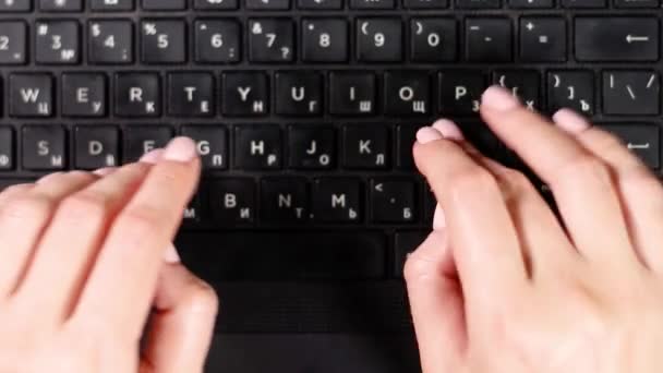 Vrouwelijke handen typen op een laptop heel close-up. Bovenaanzicht - Video