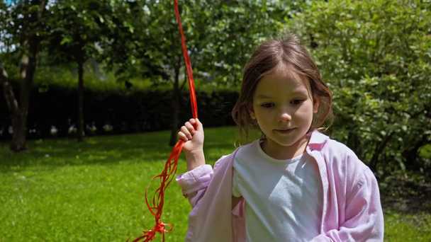 Nettes Kind läuft mit bunten Luftballons im Park  - Filmmaterial, Video