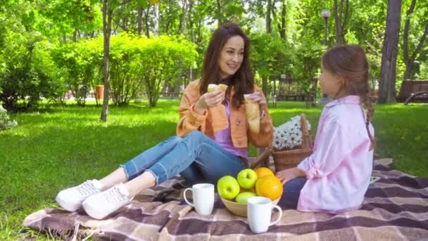 madre e hija comiendo baguette en el picnic
  - Imágenes, Vídeo